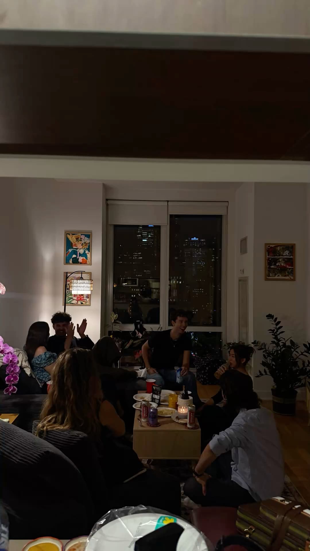 Friends laughing around a candlelit table at night